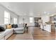 Bright, open-concept living room and kitchen with stainless steel appliances and a large sectional couch at 4692 Hatcher Dr, Brighton, CO 80601
