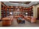 A handsome library featuring floor to ceiling bookshelves, leather sofas, and refined details at 5455 Landmark Pl # 1103, Greenwood Village, CO 80111