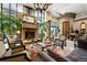 An elegant living room with a stone fireplace, large windows, and comfortable seating arrangement at 5455 Landmark Pl # 1103, Greenwood Village, CO 80111