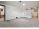 Basement featuring carpet floors, white paneled walls, and a sliding barn door, offers versatility at 4833 S Elati St, Englewood, CO 80110