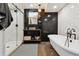 Modern bathroom boasting a soaking tub, glass shower, and a vanity sink with black and white accents at 4833 S Elati St, Englewood, CO 80110