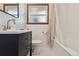 Modern bathroom featuring dark vanity, white tile, and updated fixtures at 4833 S Elati St, Englewood, CO 80110