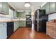 Charming kitchen features green cabinetry, black appliances, and butcher block countertops at 4833 S Elati St, Englewood, CO 80110