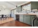 Updated kitchen with stainless steel appliances, green cabinets, and a dining area at 4833 S Elati St, Englewood, CO 80110