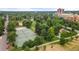 An aerial view of lush green community park, tennis courts, and play areas at 1182 Clermont St # 201, Denver, CO 80220