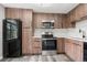 Kitchen featuring stainless steel appliances, wood cabinets, and a sleek design at 1182 Clermont St # 201, Denver, CO 80220