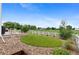 Expansive backyard featuring a stone patio with outdoor dining, mature trees, and white fence at 601 Morrison Dr, Frederick, CO 80530
