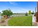 Spacious backyard featuring a playhouse, lush green lawn, white fence, and mature trees offers privacy at 601 Morrison Dr, Frederick, CO 80530