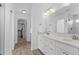 Ensuite bathroom featuring a double vanity, white cabinets, and entry to walk-in closet at 601 Morrison Dr, Frederick, CO 80530