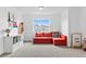 A bonus room features a red couch, a rainbow decoration, and carpeted floors at 601 Morrison Dr, Frederick, CO 80530