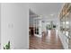 Bright hallway with hardwood floors, white trim, and doorways leading to other rooms of the home at 601 Morrison Dr, Frederick, CO 80530