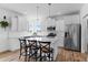 A kitchen island features white cabinets, stone countertops, and three black chairs at 601 Morrison Dr, Frederick, CO 80530