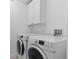 Laundry room with front-loading washer and dryer and white cabinets for storage at 601 Morrison Dr, Frederick, CO 80530