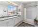 Well-lit bathroom with double sinks, a tub, and a large window with neighborhood view at 7373 E Iowa Ave # 1108, Denver, CO 80231