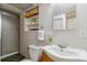 Cozy bathroom featuring a step-in shower, ample lighting, and functional storage shelf at 7373 E Iowa Ave # 1108, Denver, CO 80231