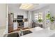 Bright kitchen with white cabinetry, stainless steel appliances, and a window overlooking the neighborhood at 7373 E Iowa Ave # 1108, Denver, CO 80231