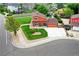 Aerial view of a home with a well-manicured front yard, a driveway, and mature trees at 7300 Beech St, Arvada, CO 80005