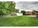 A spacious backyard features lush green grass, a shed, and privacy fencing at 7300 Beech St, Arvada, CO 80005