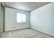 Simple bedroom with one window, neutral carpet, and plain white walls at 7300 Beech St, Arvada, CO 80005
