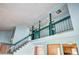 High angle interior view showing second floor railing and staircase with a glimpse of the kitchen at 7300 Beech St, Arvada, CO 80005