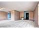 Open-concept living room with carpet and view of a wheelchair lift, connecting to a bedroom at 7300 Beech St, Arvada, CO 80005