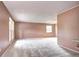 Spacious living room featuring carpet floors, light pink walls, and natural light from the windows at 7300 Beech St, Arvada, CO 80005