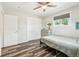 Charming bedroom featuring wood-look flooring, fan, closet, bed, and large windows at 4715 Garland St, Wheat Ridge, CO 80033