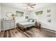 Bright bedroom boasts wood-look flooring, fan, large windows, bed, and dresser at 4715 Garland St, Wheat Ridge, CO 80033