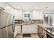 Modern kitchen with white cabinetry, stainless steel appliances, subway tile backsplash, and sleek countertops at 4715 Garland St, Wheat Ridge, CO 80033