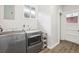 Laundry room with modern washer and dryer featuring wood-look flooring and window at 4715 Garland St, Wheat Ridge, CO 80033
