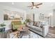 Comfortable living room featuring a ceiling fan, dark laminate flooring, and an opening into the kitchen at 4715 Garland St, Wheat Ridge, CO 80033