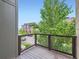 Cozy balcony with wood deck and metal railing overlooking green trees and neighborhood views at 2507 Moline St, Aurora, CO 80010