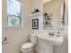 Bright half bath with pedestal sink, open shelving, and a window with natural light at 2507 Moline St, Aurora, CO 80010
