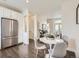 Bright dining area with stainless steel fridge, white cabinets, and hardwood floors at 2507 Moline St, Aurora, CO 80010