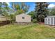 Well-maintained backyard showcasing two storage sheds, grassy lawn, and mature trees at 3209 E Yale Way, Denver, CO 80210