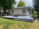 Backyard deck, small fence, string lights, siding, a small window, and a patch of green grass at 3209 E Yale Way, Denver, CO 80210