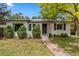 Inviting home showcasing a neatly landscaped yard, stone pathway, and solar panels, enhancing curb appeal at 3209 E Yale Way, Denver, CO 80210
