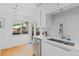 Bright kitchen features white cabinets, stainless steel appliances, hardwood floors, and backyard views at 3209 E Yale Way, Denver, CO 80210