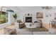 Bright living room with white walls, fireplace, plush seating, with large windows offering views of the outdoor greenery at 3209 E Yale Way, Denver, CO 80210