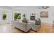 Bright living room with white walls, fireplace, plush seating, with large windows offering views of the outdoor greenery at 3209 E Yale Way, Denver, CO 80210