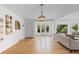 Bright living room with white walls and wood flooring showcasing large windows offering views of the well landscaped exterior at 3209 E Yale Way, Denver, CO 80210