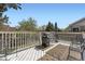 Relaxing back deck with a grill, outdoor seating, and a view of the surrounding trees at 4222 S Himalaya Way, Aurora, CO 80013
