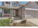 Inviting front entrance with brick accents, a cozy porch, and a well-manicured lawn at 4222 S Himalaya Way, Aurora, CO 80013