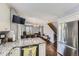 Well-appointed kitchen with stainless steel appliances, an island with seating, and a view of the living area at 4222 S Himalaya Way, Aurora, CO 80013