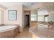 Bright bathroom with a soaking tub, dual sinks, tile flooring, and large mirrors at 17 Canon Dr, Greenwood Village, CO 80111