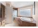 Lovely bathroom featuring a tiled shower, soaking tub, and frosted glass block window at 17 Canon Dr, Greenwood Village, CO 80111