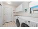 Well lit Laundry room featuring a front load washer and dryer, and a utility sink at 17 Canon Dr, Greenwood Village, CO 80111