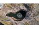 Aerial view of a serene pond featuring a water fountain surrounded by mature trees and rock landscaping at 17 Canon Dr, Greenwood Village, CO 80111