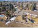 Aerial view of a home in a serene neighborhood with mature trees and views of the mountains at 4192 S Vrain St, Denver, CO 80236