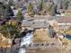 Backyard aerial of home featuring mature trees, partial snow coverage, shed and trampoline at 4192 S Vrain St, Denver, CO 80236